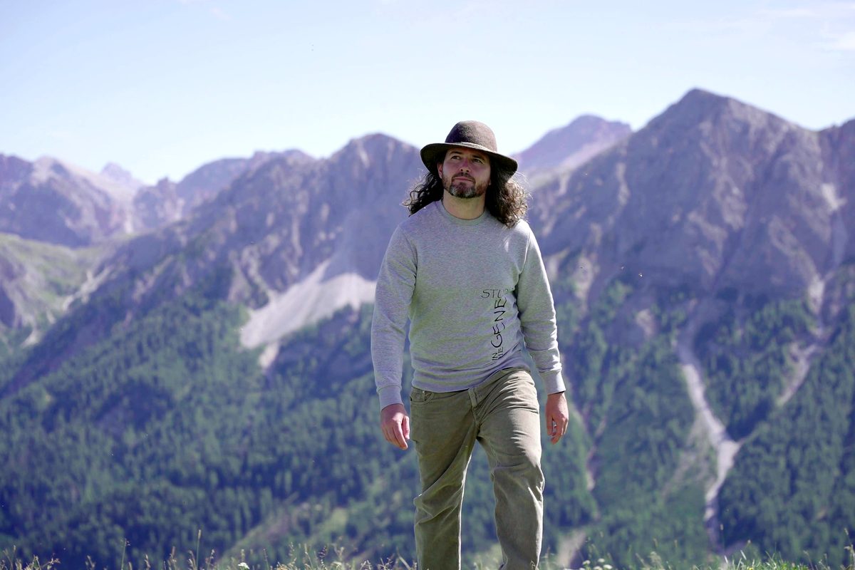 Benjamin Lechner mit Hut vor der Bergkette der Dolomiten.